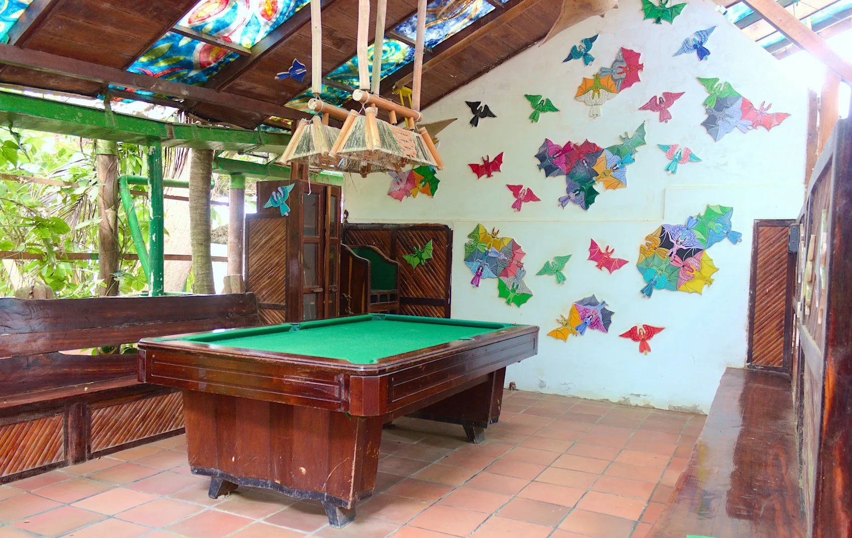 A pool table in a bright room with colourful wall decorations